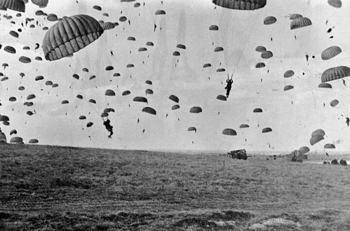 Paraquedistas aliados saltando sobre a Holanda durante a Operação Market Garden em 17 de setembro de 1944, com aeronaves C-47 ao fundo.